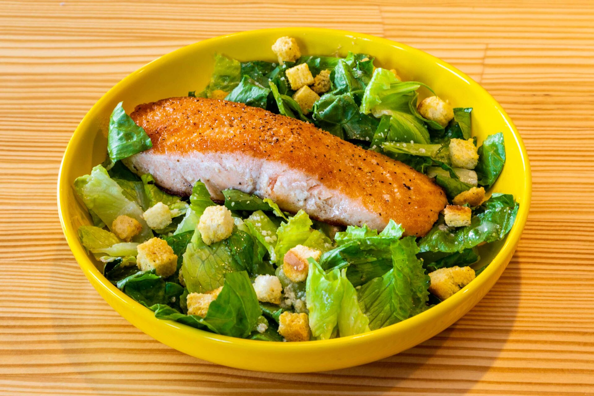 A bowl of salad with chicken and corn.