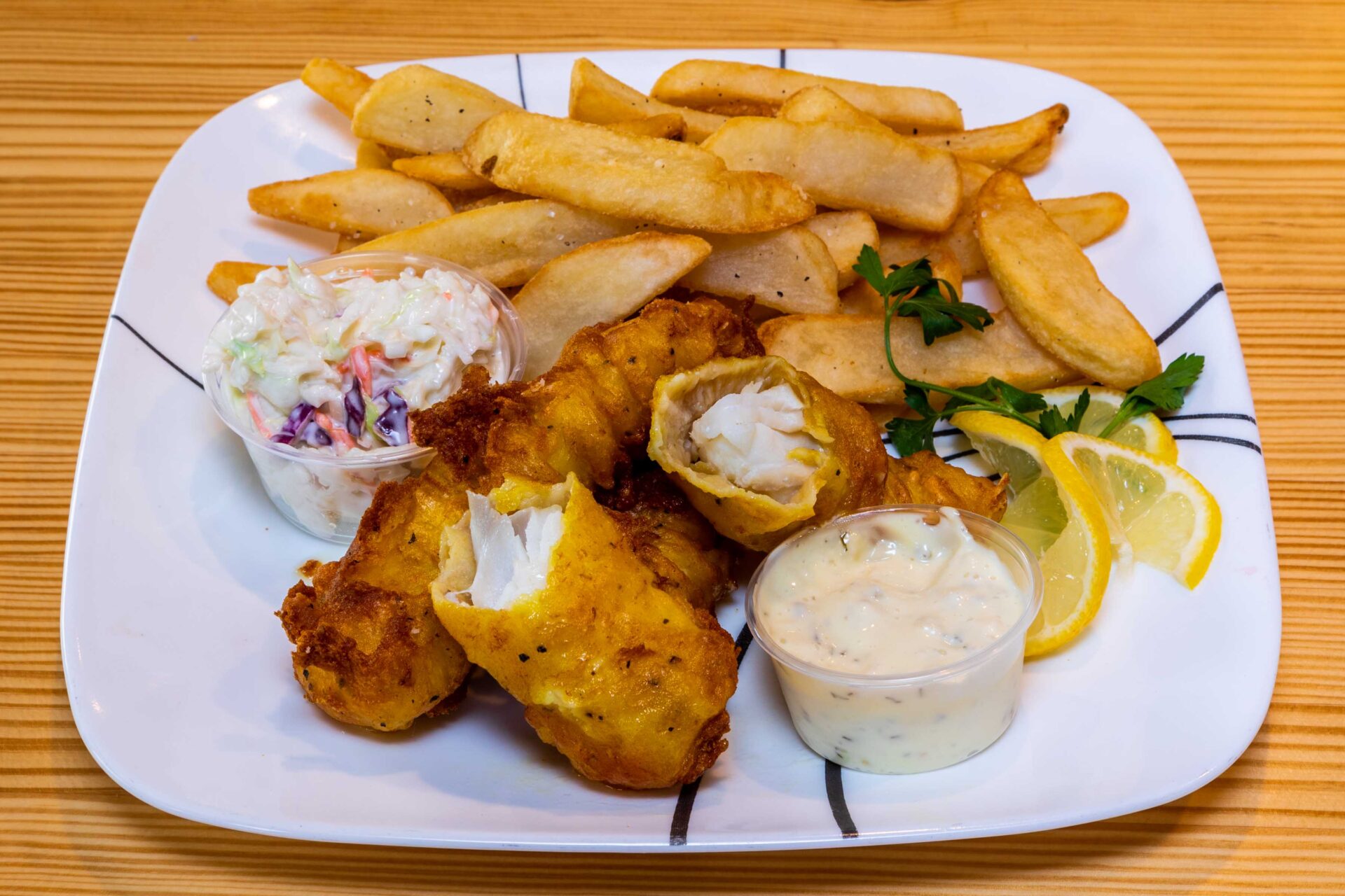 A plate of food with fish and fries on it.
